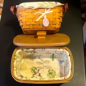 2 New Longaberger handmade baskets 1 w/lid; 1 w/leather handles 7” floral